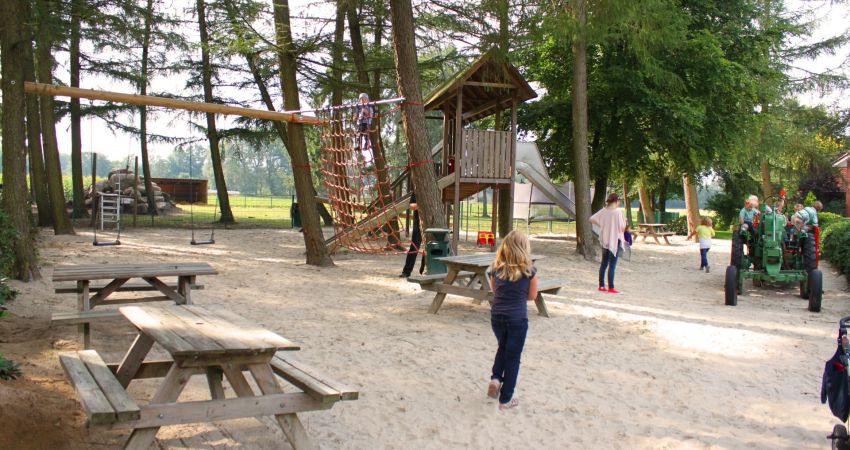 Spielplatz mit Kindern, Spielturm und Traktor