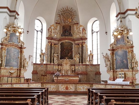 St. Andreas-Kirche in Cloppenburg: Innenansicht einer Kirche mit Altar, Bänken und reichhaltiger Dekoration.