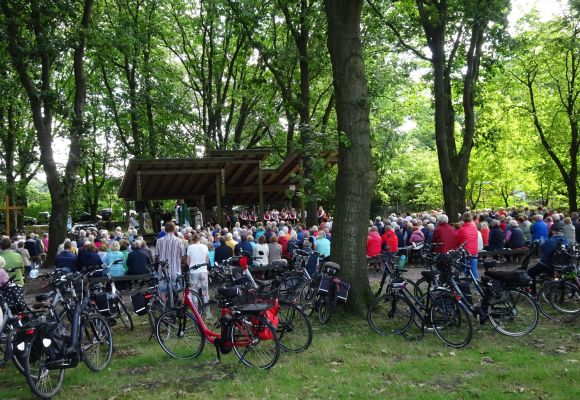 Freiluftgottesdienst. Viele Menschen vor einer Bühne auf dem Aktionsplatz, Fahrräder im Vordergrund.